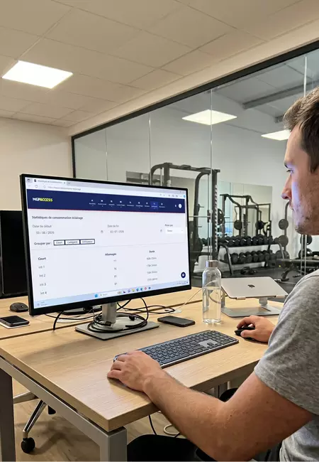 Gérant de salle de sport consultant le logiciel MGP Access sur ordinateur