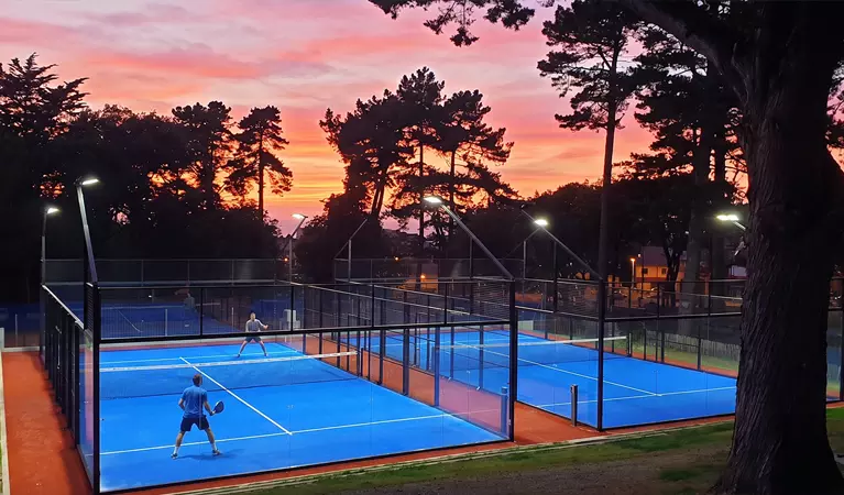 Éclairage LED MGP Matic allumé sur des courts de padel extérieurs au coucher du soleil, vue mobile